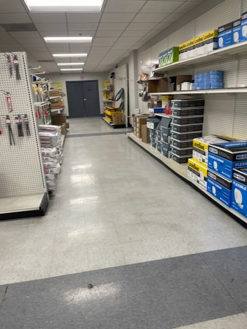 Commercial retail VCT tile floor before stripping and waxing — dull and worn with visible wear marks